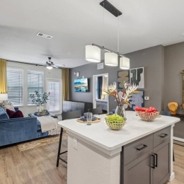 kitchen with island with fruit on itand an view of a living room